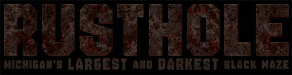 The Rusthole attraction logo featuring weathered, textured orange-red text against a solid black background. Subtext reads: Michigan's Largest and Darkest Black Maze.